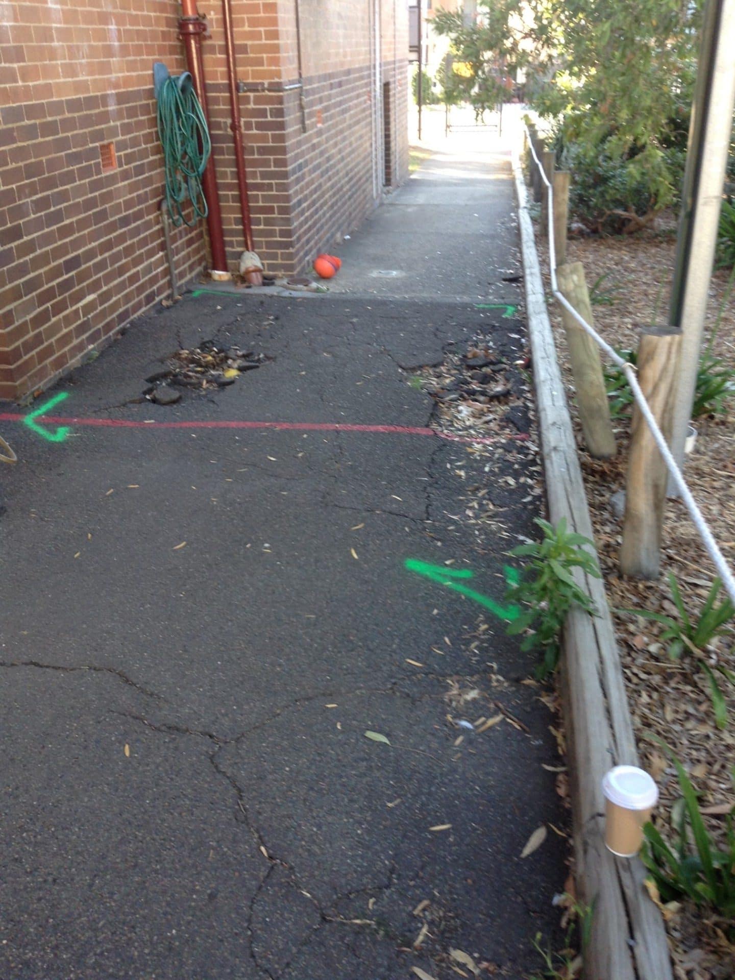 Cracked asphalt walkway marked out for repair at Colyton Public School, Mt Druitt NSW