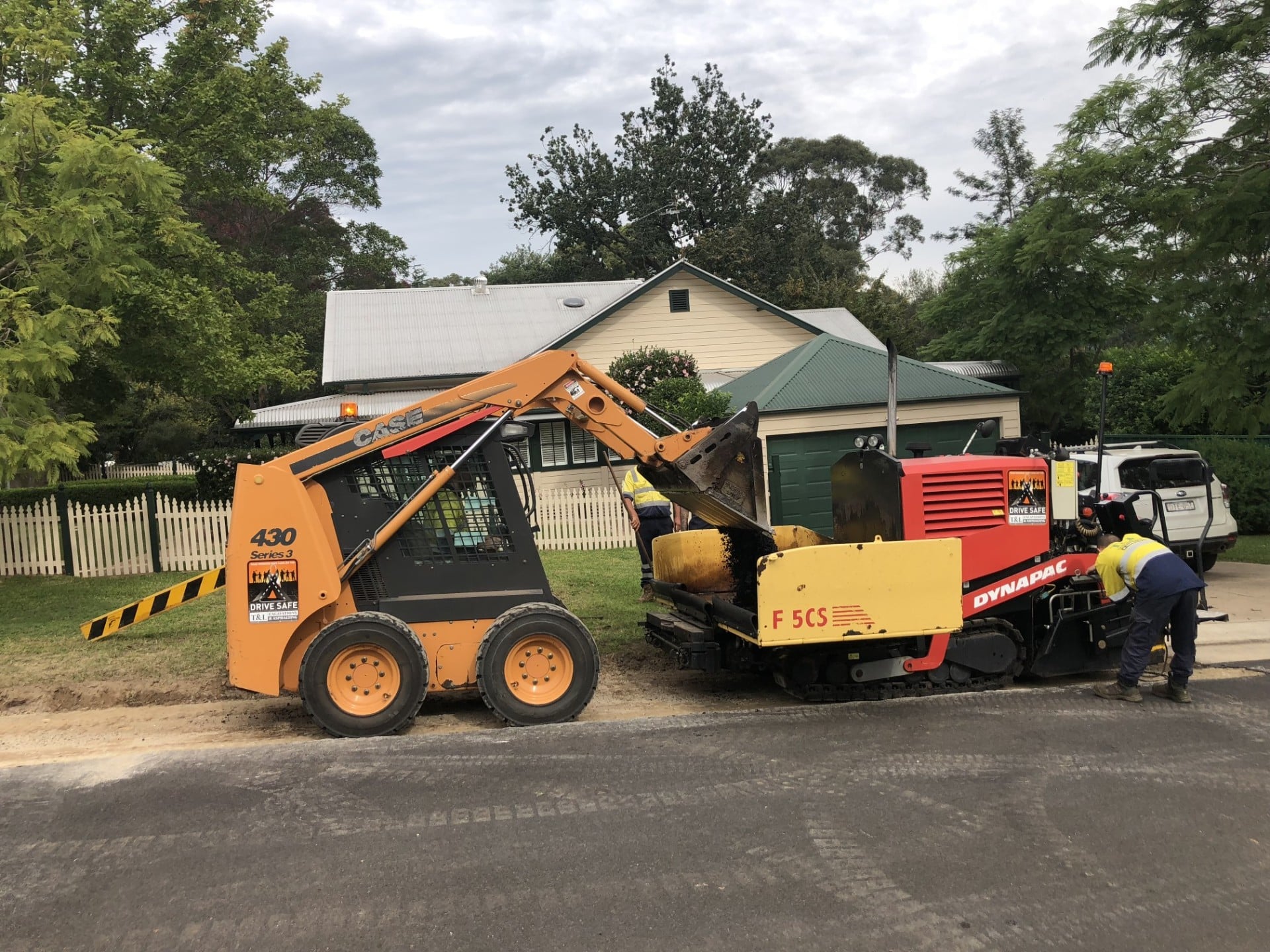 Mini asphalt paver preparing to lay asphalt on a road shoulder